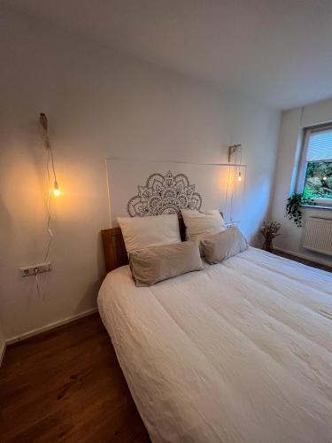 a bedroom with a large white bed with two pillows at Bergoase in Unteropfingen