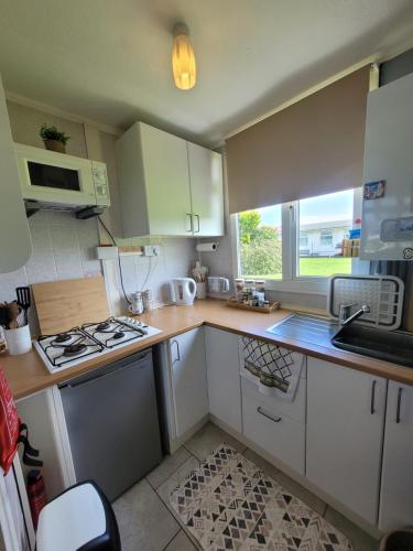 a kitchen with white cabinets and a stove top oven at Casa B.R.I in Mablethorpe