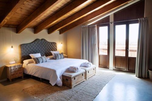 a bedroom with a large bed and a large window at Hotel Mas De Cebrian in Puertomingalvo