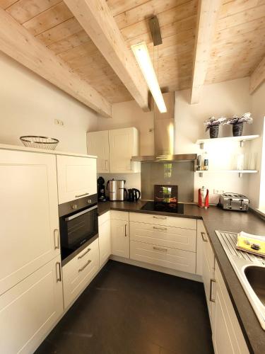 a kitchen with white appliances and wooden ceilings at Winterberg Chalet 21096 in Winterberg