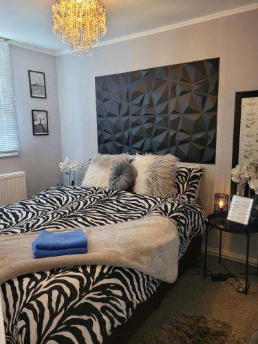 a bedroom with a zebra print bed with a chandelier at Casa B.R.I in Mablethorpe