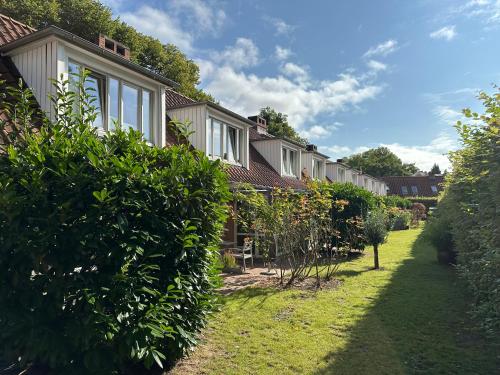 a row of houses in a yard with bushes at Landhaus Jenischpark in Hamburg
