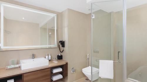 a bathroom with a toilet and a sink and a shower at Holiday Inn Gurugram Sector 90 by IHG in Gurgaon