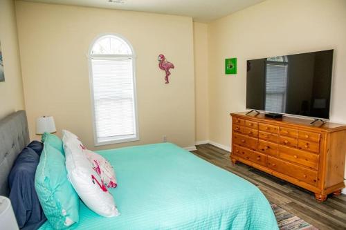 a bedroom with a bed and a dresser with a television at 2 BR Condo W/ Golf Cart & Pool (Pet-Friendly) in Myrtle Beach