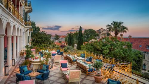 a patio with chairs and tables on a balcony at Hilton Imperial Dubrovnik in Dubrovnik