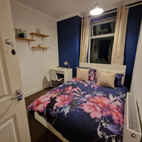 a bedroom with a bed with a floral bedspread at Double room in Heaton in Heaton