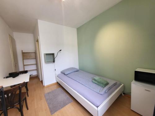 um pequeno quarto com uma cama e uma secretária em Casa Maria Apartments em Solothurn