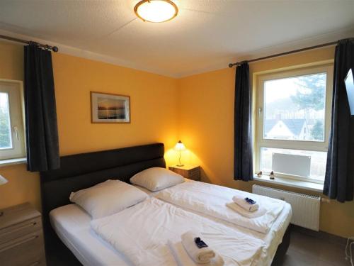 una camera da letto con un letto e due asciugamani di Ostsee-Residenz, Whg 21 a Zingst