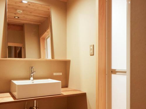 a bathroom with a white sink and a mirror at sakainoma hotel 熊 in Sakai