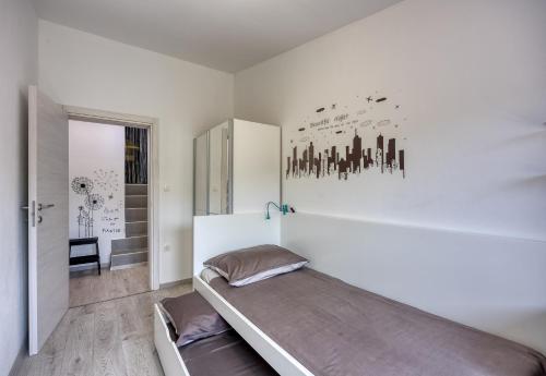 um quarto branco com uma cama e uma parede com edifícios em Family Friendly House Kacana - Happy Rentals em Vodnjan