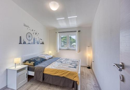 um quarto branco com uma cama e uma janela em Family Friendly House Kacana - Happy Rentals em Vodnjan