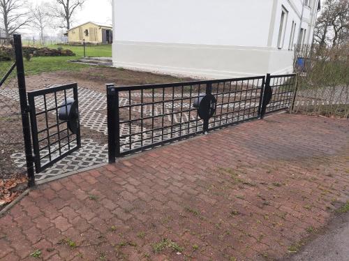 a black fence with two parking meters on it at Ferienwohnung Gutshaus Klitzschen in Mockrehna
