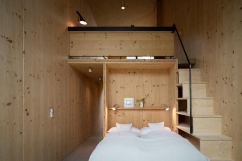 Un dormitorio con una cama en una habitación con paredes de madera. en quartier - über Nacht in besonderer Architektur, en Garmisch-Partenkirchen
