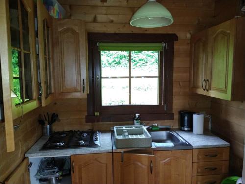 a kitchen with a sink and a stove and a window at Domek nad jeziorem Rożnowskim - Gródek Nad Dunajcem in Gródek Nad Dunajcem
