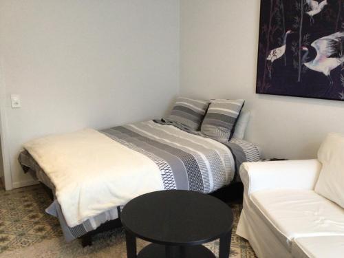 um quarto com duas camas, uma mesa e um sofá em Black and white em Profondeville