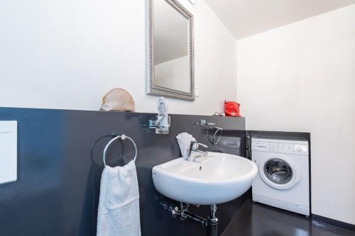 a bathroom with a sink and a washing machine at Chasa Muglin Ardez in Ardez