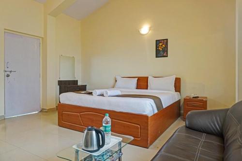 een hotelkamer met een bed en een bank bij Hotel Pratham Lotus in Panchgani