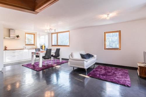 a living room with a couch and a table and chairs at Chasa Muglin Ardez in Ardez