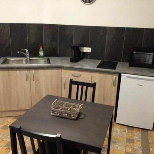 a kitchen with a table with chairs and a sink at Black and white in Profondeville