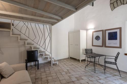 a living room with a staircase and a table and chairs at Casa Mimina in Ischia