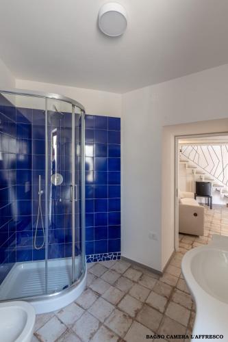 a bathroom with a shower and a blue tiled wall at Casa Mimina in Ischia