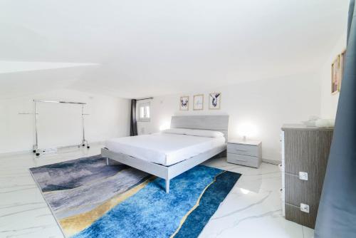 a white bedroom with a bed and a blue rug at Casa Alexander in Nocera Inferiore