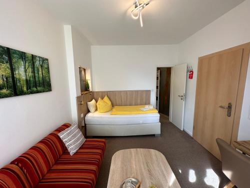 a living room with a couch and a bed at Pension Alscher Garni in Goslar