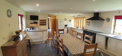 a kitchen with a table and some chairs in it at Spacious Luxury barn conversion - next to Tarka Trail cycle path in Great Torrington