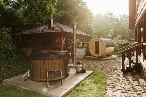 a wooden gazebo with a wooden tub in a yard at Cabin Sonka in Oščadnica
