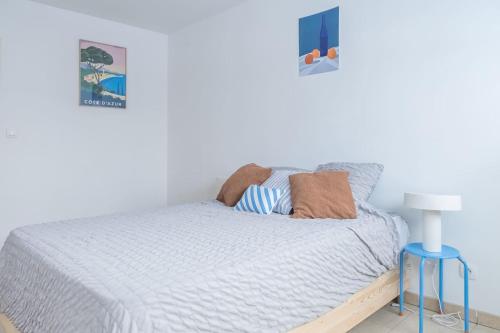 - une chambre avec un lit et un tabouret bleu dans l'établissement T2 Panier avec loggia, à Marseille