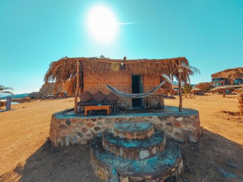 a small hut with a hammock on the beach at New Moon Island Camp in Nuweiba
