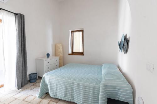 a white bedroom with a bed and a window at Casa Mimina in Ischia