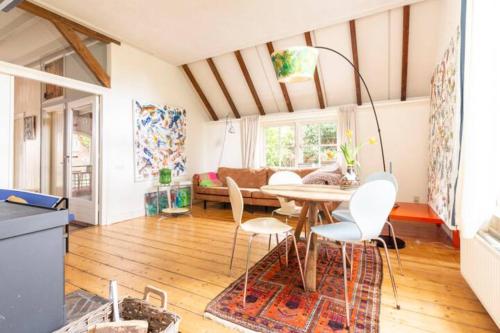 een woonkamer met een tafel en stoelen bij Heerlijke boerderij bij Veluwezoom in het Oude Dieren in Dieren