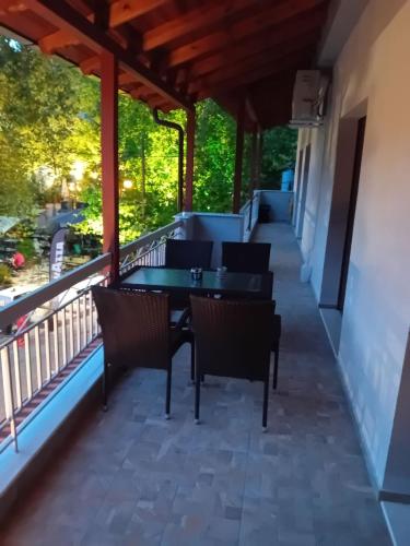 eine Terrasse mit Stühlen und einem Tisch auf dem Balkon in der Unterkunft Ξενωνας Κάρμα in Orma