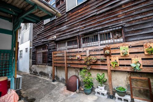una pared de madera con plantas en el lateral de un edificio en 家暖暖,老屋新生,房源內有戶外空間,嘉義市民宿013號, en Chiayi