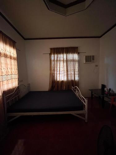ein großes Bett in einem Zimmer mit zwei Fenstern in der Unterkunft Jessie’s Place in Banlik