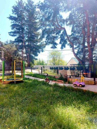 einen Park mit Spielplatz mit Spielzeug im Gras in der Unterkunft GUEST HOUSE 'KIDOBANI' in Surami