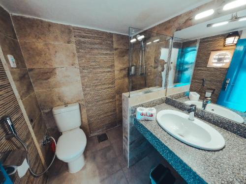 a bathroom with a sink and a toilet and a mirror at New Moon Island Camp in Nuweiba