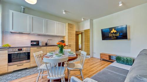 a kitchen and living room with a table and chairs at Apartament Górska 5 by Royal Aparts in Świeradów-Zdrój