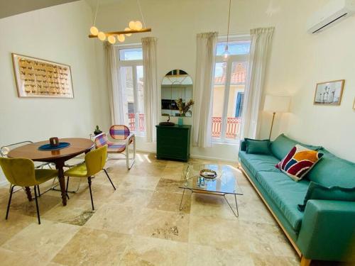 un salon avec un canapé vert et une table dans l'établissement ''Le Refuge'' Duplex Quartier Haut, climatisé, à Sète