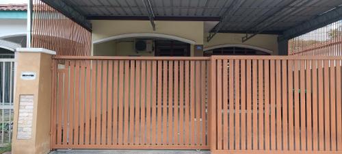 a wooden gate in front of a house at Rumah Inap Bandar Puteri Jaya Sungai Petani in Sungai Petani