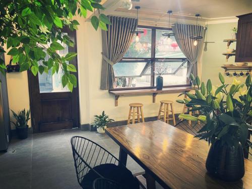 a dining room with a wooden table and chairs and a window at BabaHouse-Homestay Thành phố Vinh in Bến Thủy