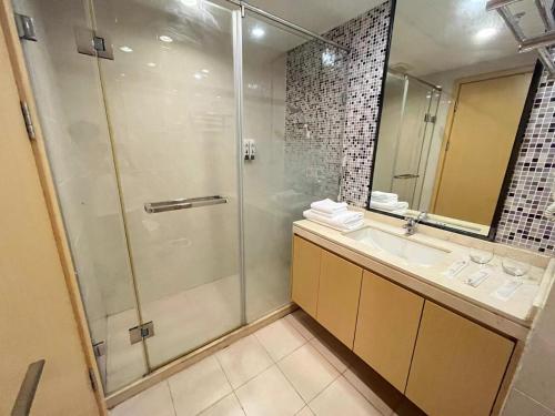a bathroom with a shower and a sink and a mirror at Seaman Light Luxury Apartment in Zhongshan