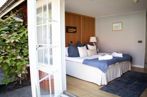 a bedroom with a bed and a door open at Gränsö Slott Hotel & Spa in Västervik