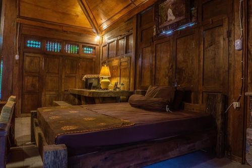 - une chambre avec un lit dans une pièce en bois dans l'établissement Din House Jembrana, à Negara