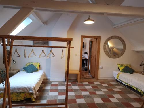 a bedroom with two beds and a mirror at Eremyten Hof in Evergem