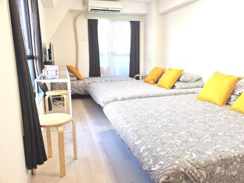 1 dormitorio con 2 camas, mesa y silla en DP House, en Tokio