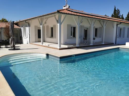 une grande piscine en face d'une maison dans l'établissement Belle chambre d'hôtes avec petit déjeuner chez Phil et Isa, à Nérac