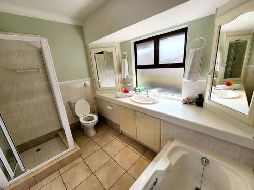 La salle de bains est pourvue d'une baignoire, de toilettes et d'un lavabo. dans l'établissement Villa A13 - Selborne Golf Estate, à Pennington