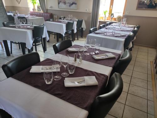 una fila de mesas en un restaurante con vasos y servilletas en Les studios du frankenthal en Stosswihr